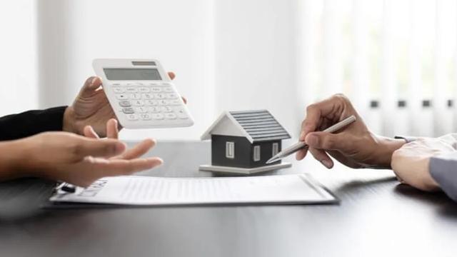Duas pessoas calculando impostos em negociação do imóvel.