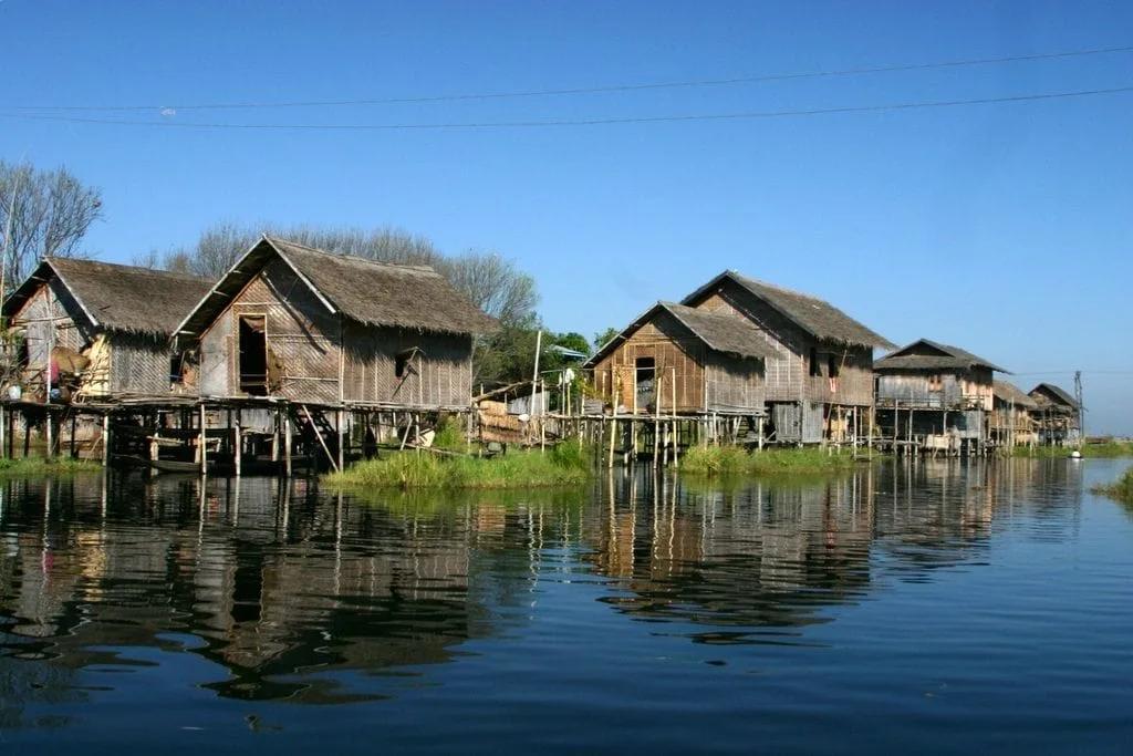 Palafitas Casas de madeira sobre estacas refletidas na água calma de um lago