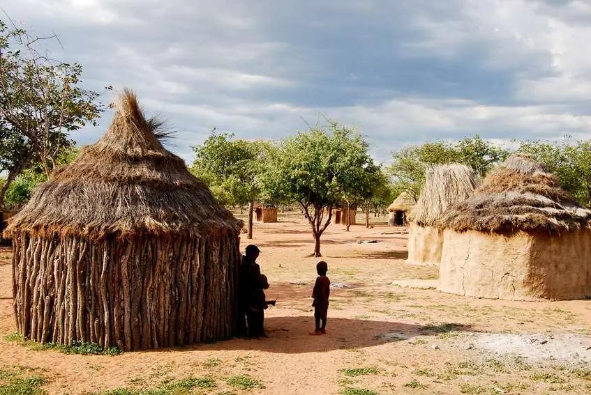 Casas himba Casas circulares de barro e madeira com coberturas cônicas de palha em uma aldeia de terra batida