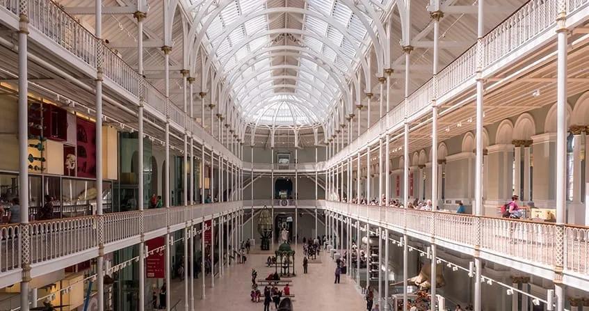 Grande salão do Museu Nacional da Escócia Grande salão do Museu Nacional da Escócia, com galerias em vários níveis e cobertura de vidro sustentada por estrutura de ferro