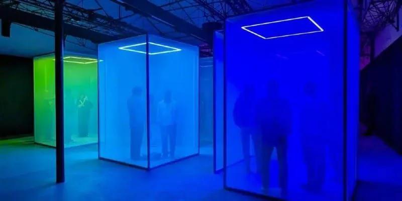 Making Sense of Color, do Google com Chromasonic Cabines de tela semitransparente iluminadas em azul e verde na exposição Making Sense of Color