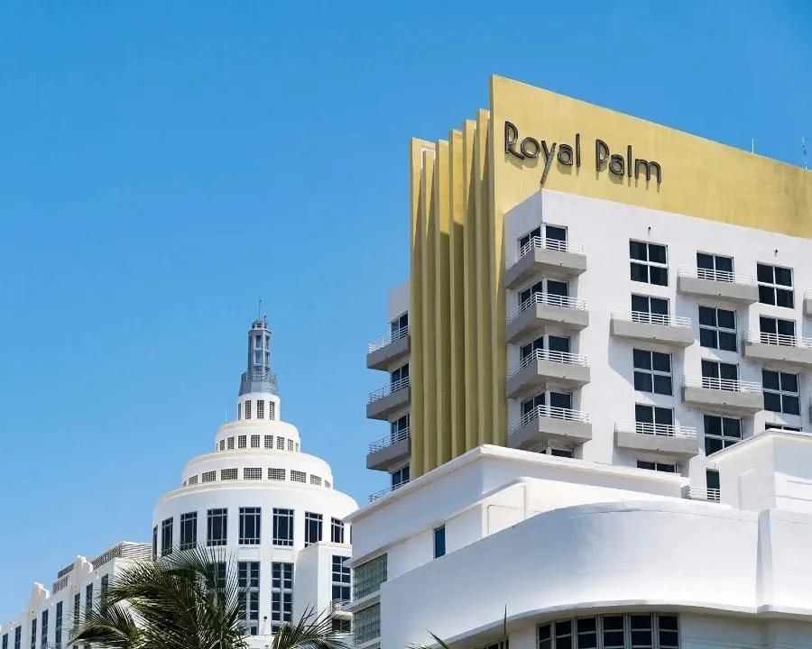 Hotéis Art Déco em Miami Beach Hotéis brancos e amarelos de Miami Beach com letreiro vertical e cúpula, sob céu azul