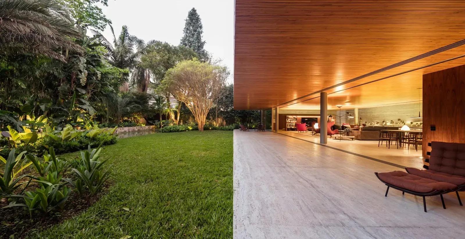 Varanda com forro de madeira e piso claro aberta para um jardim tropical