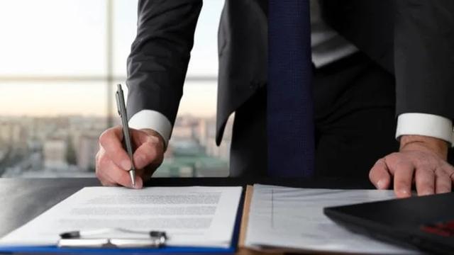 Pessoa assinando documentos para Averbação de imóveis.