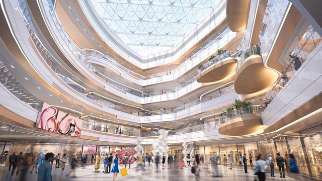 Foto de pátio interno central de um grande shopping center, rodeado de lojas e cheio de pessoas caminhando por ele