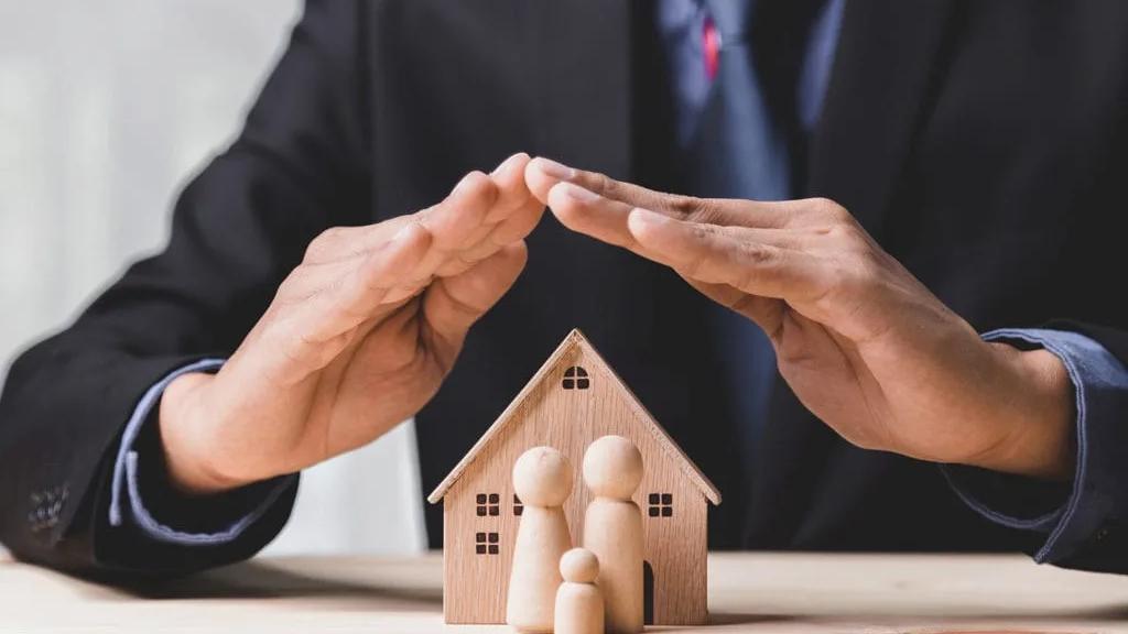 Gestão de imóveis por uma holding patrimonial Homem ajustando a maquete de uma casa, representando a gestão dos imóveis de uma holding patrimonial