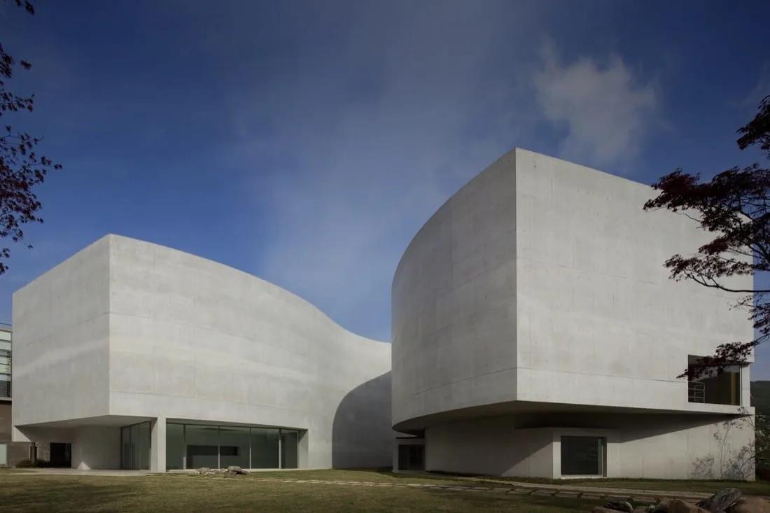 Museu Mimesis, de Álvaro Siza Edifício de volumes brancos curvos com poucas aberturas, sobre um gramado