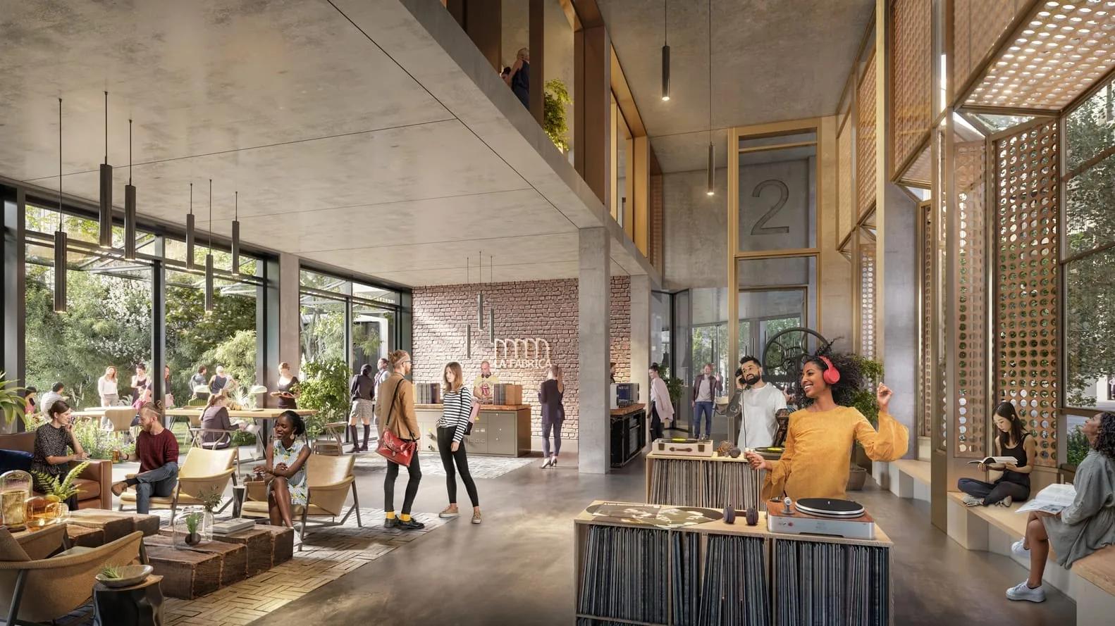 Salão amplo de um coliving com pé-direito alto, pessoas conversando, bar e plantas