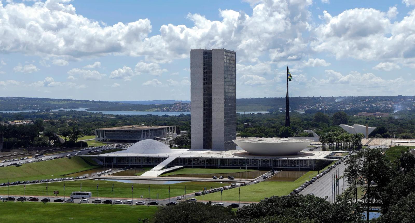 Congresso Nacional, Brasília Vista do alto do Congresso Nacional: duas torres no centro, a cúpula menor à esquerda e a cúpula invertida, maior, à direita, com o lago Paranoá ao fundo