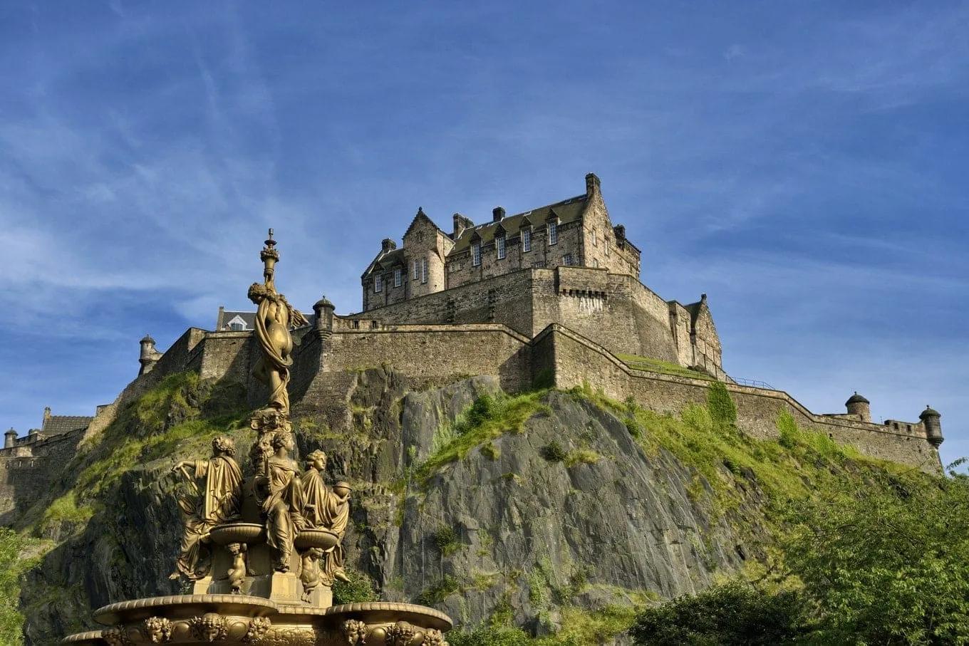 Castelo de Edimburgo sobre a rocha vulcânica, visto dos Jardins da Princes Street, com a fonte ornamentada Ross em primeiro plano
