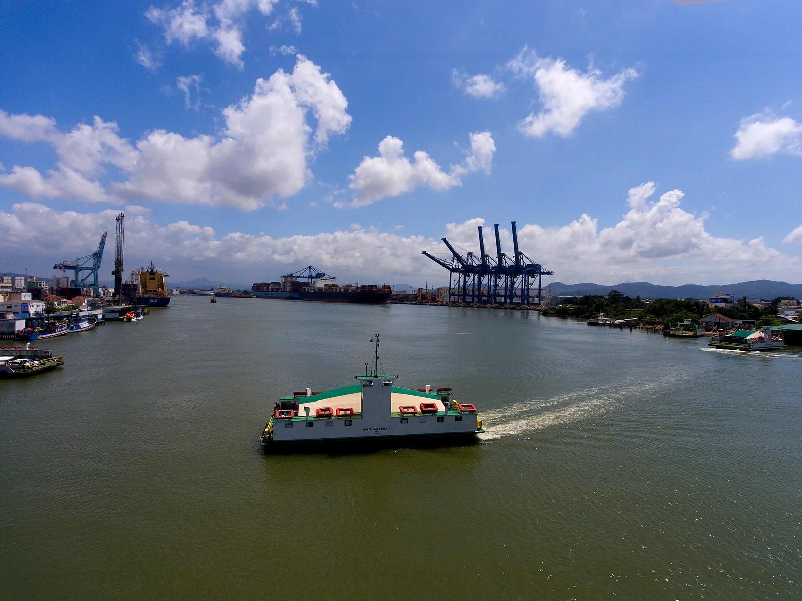 Balsa atravessando o rio Itajaí-Açu entre Itajaí e Navegantes, com os guindastes do porto ao fundo