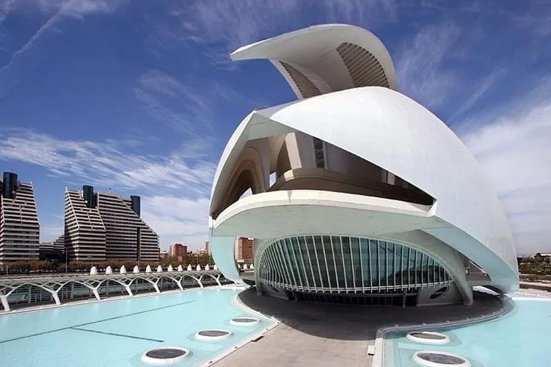 Palau de les Arts Reina Sofía Palau de les Arts, edifício branco com grande cobertura curva em forma de pala, sobre espelho d'água