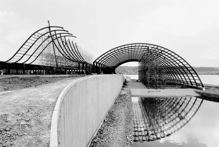 Arcos metálicos em construção à beira do lago, em foto em preto e branco