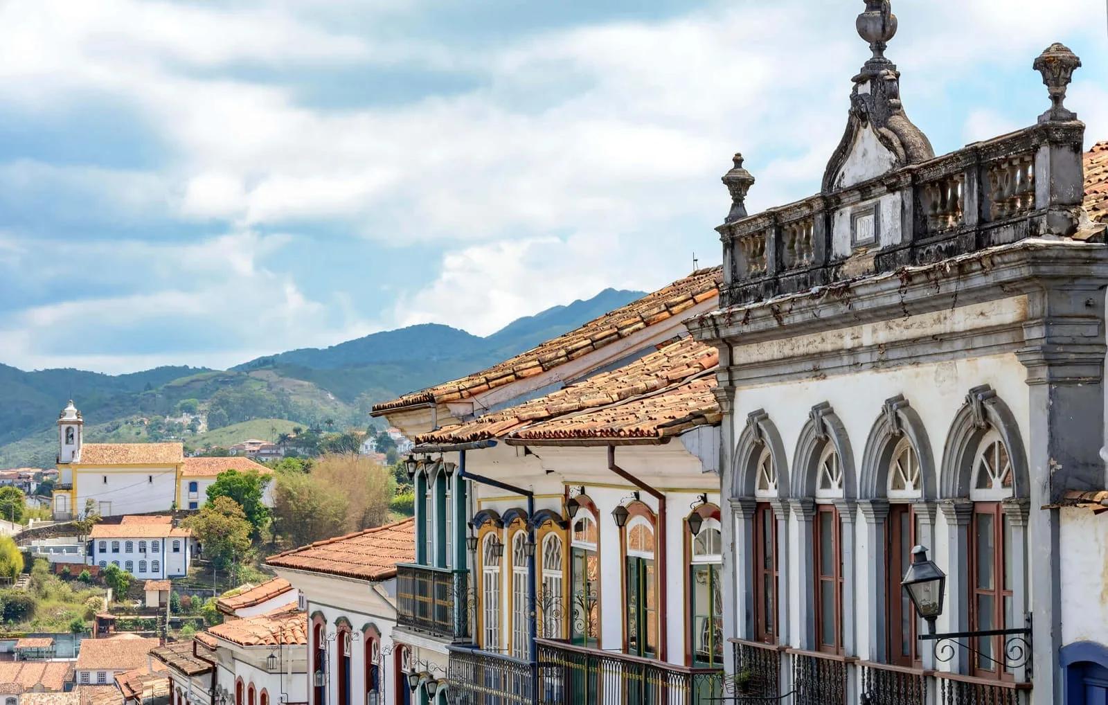 Rua de Ouro Preto com sobrado colonial de sacadas e igreja ao fundo