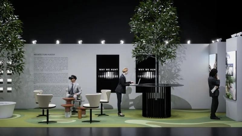 Estande do Architecture Hunter Estande expositivo do Architecture Hunter com árvores, mesas redondas, painéis com os dizeres Why we hunt e visitantes, um deles usando óculos de realidade virtual