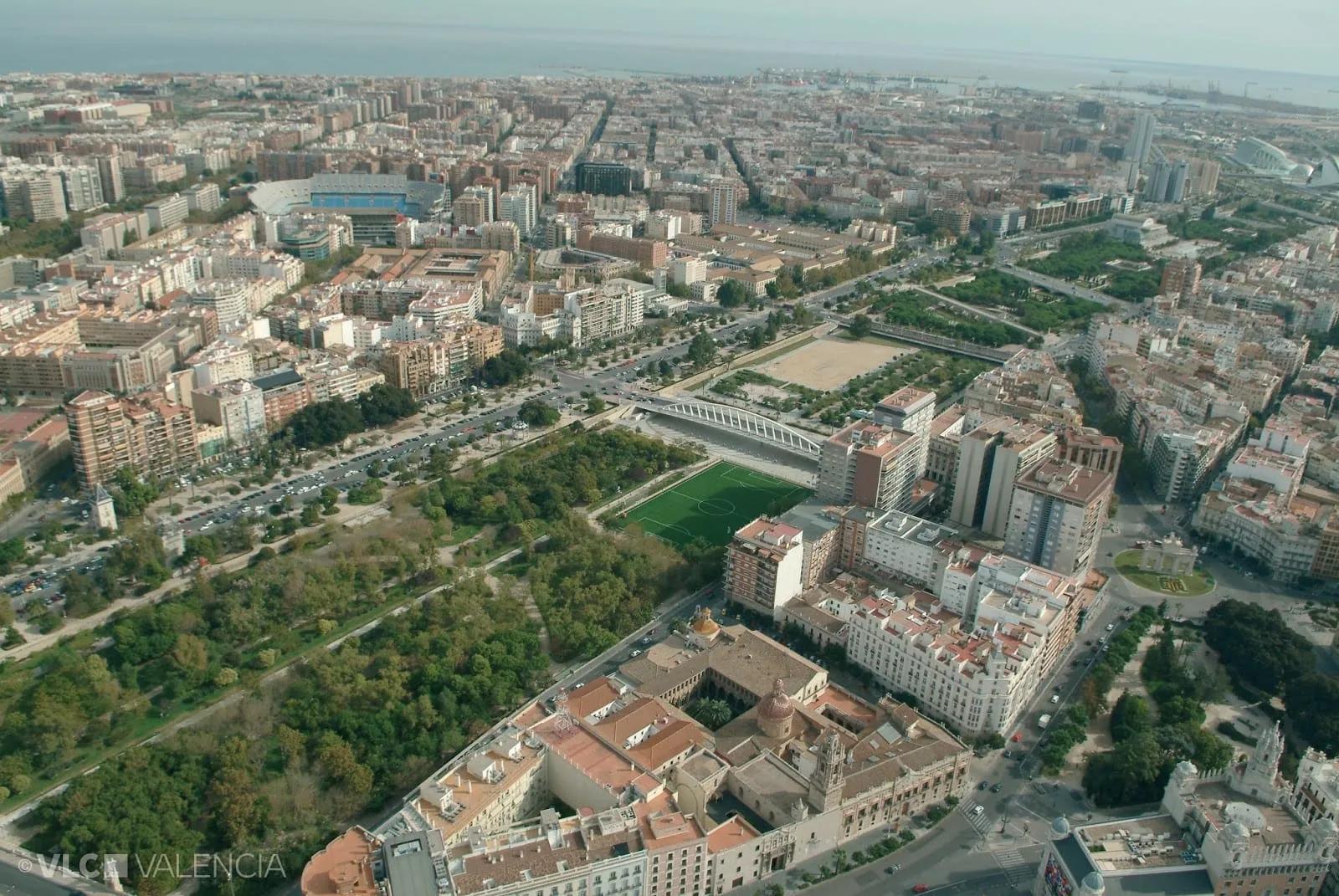 Vista aérea de Valência com o Jardim do Túria atravessando a cidade como uma faixa verde entre prédios