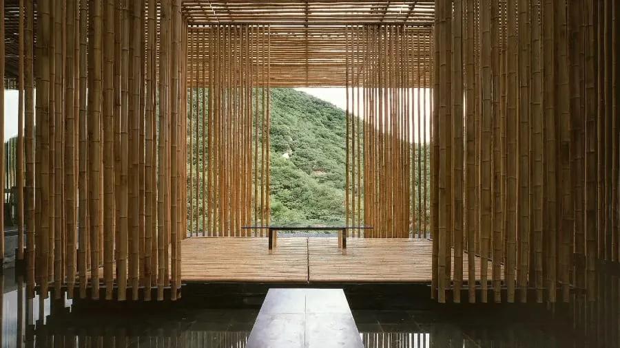 Sala envolvida por varas de bambu com vista para a montanha, na Great (Bamboo) Wall