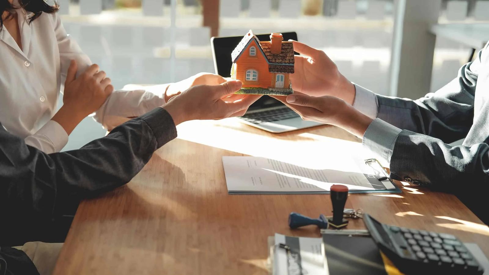 Consultor imobiliário orientando investidores com documentos.