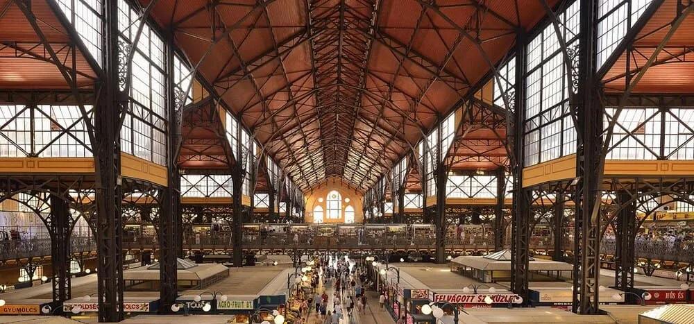 Mercado Central de Budapeste Interior do Mercado Central de Budapeste com bancas em dois níveis sob a grande estrutura metálica do telhado