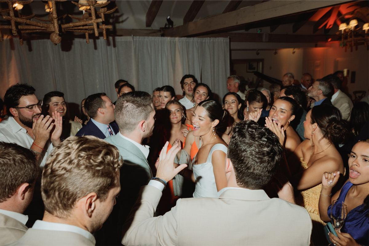 Crowded dance floor of guests dancing shoulder to shoulder at the reception