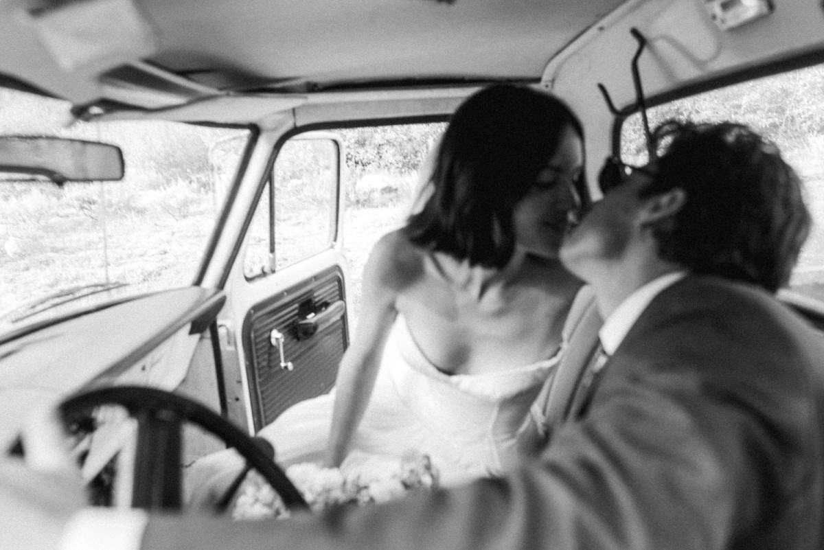 Owen kisses Devin in the cab of a vintage pickup truck at a mountain ranch among the aspens, black and white