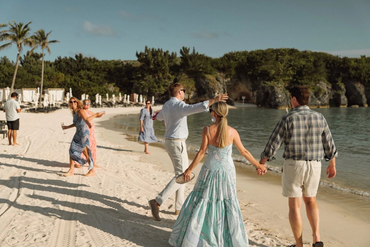 Guests walking the beach hand in hand at a Bermuda welcome party