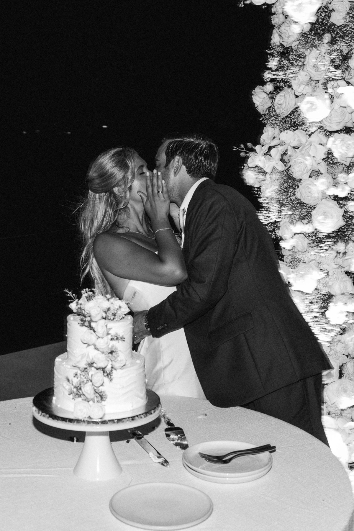 Paige and Cam kiss over the cake on Hawkins Island, Bermuda, black and white