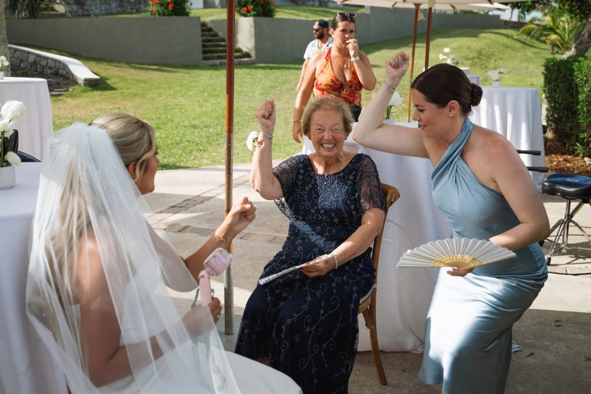 Guests cheer and wave fans as Paige passes on her way to the ceremony on Hawkins Island, Bermuda