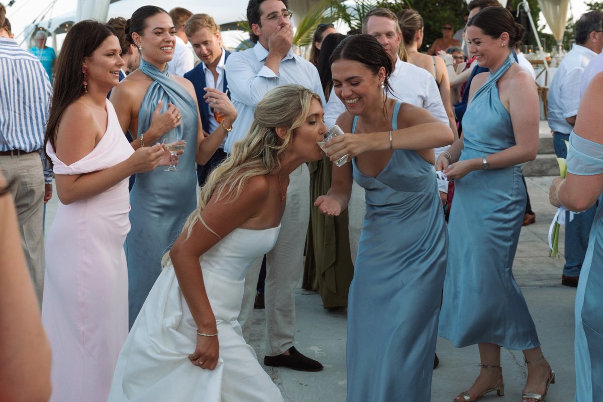 Paige takes a shot with her bridesmaids on the terrace on Hawkins Island, Bermuda
