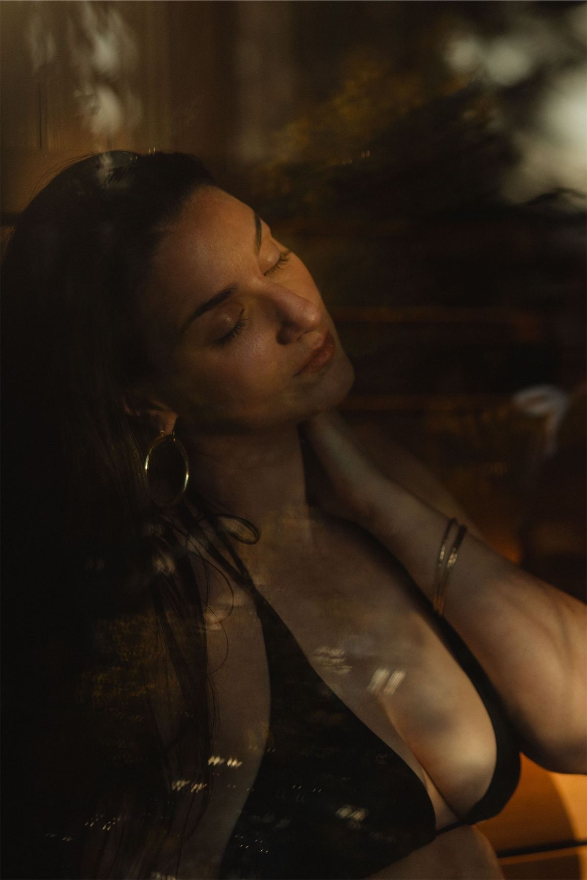 Portrait of a woman resting behind glass with warm evening light across her face