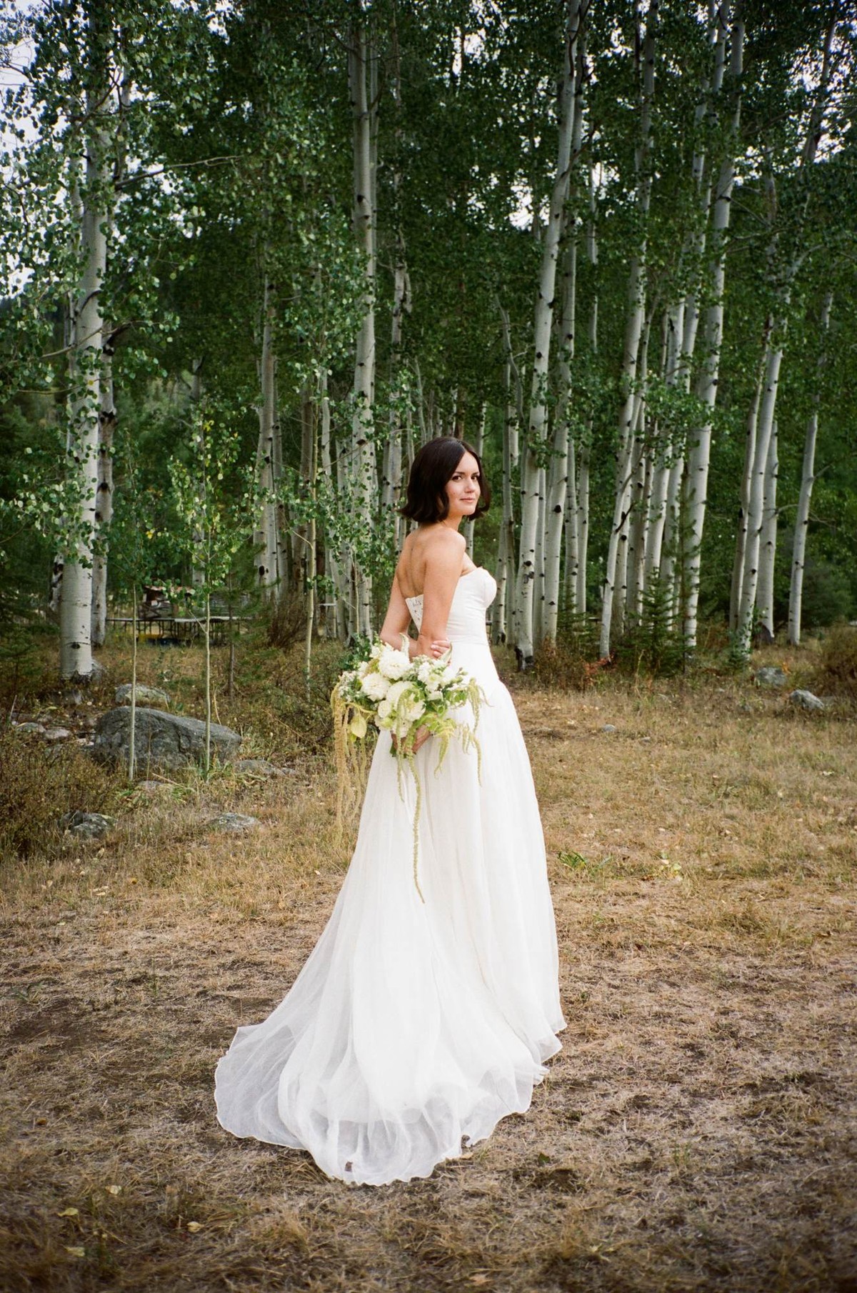 Devin looks back over her shoulder at the edge of the aspen grove, shot on film at a mountain ranch among the aspens
