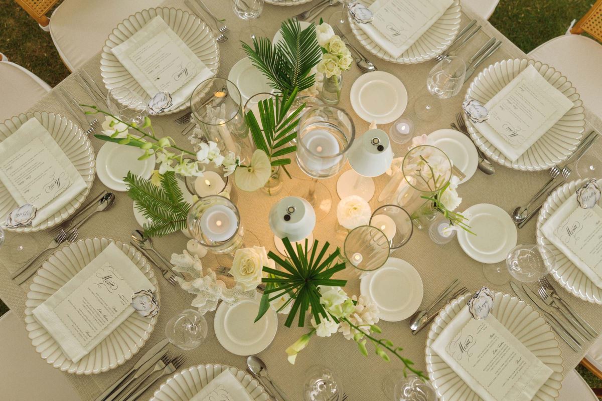 Overhead tablescape with palm fronds, candlelight and printed menus