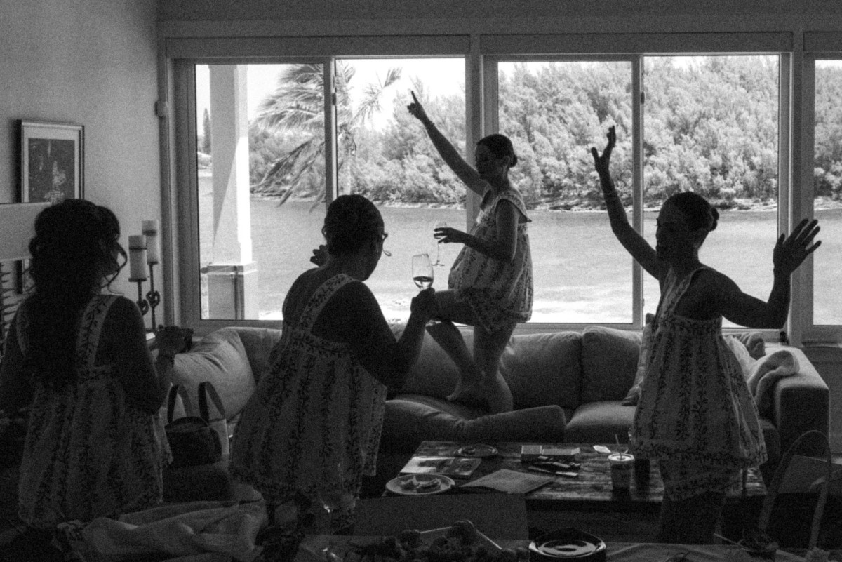 Bridesmaids dance in silhouette against the morning window on Hawkins Island, Bermuda, black and white