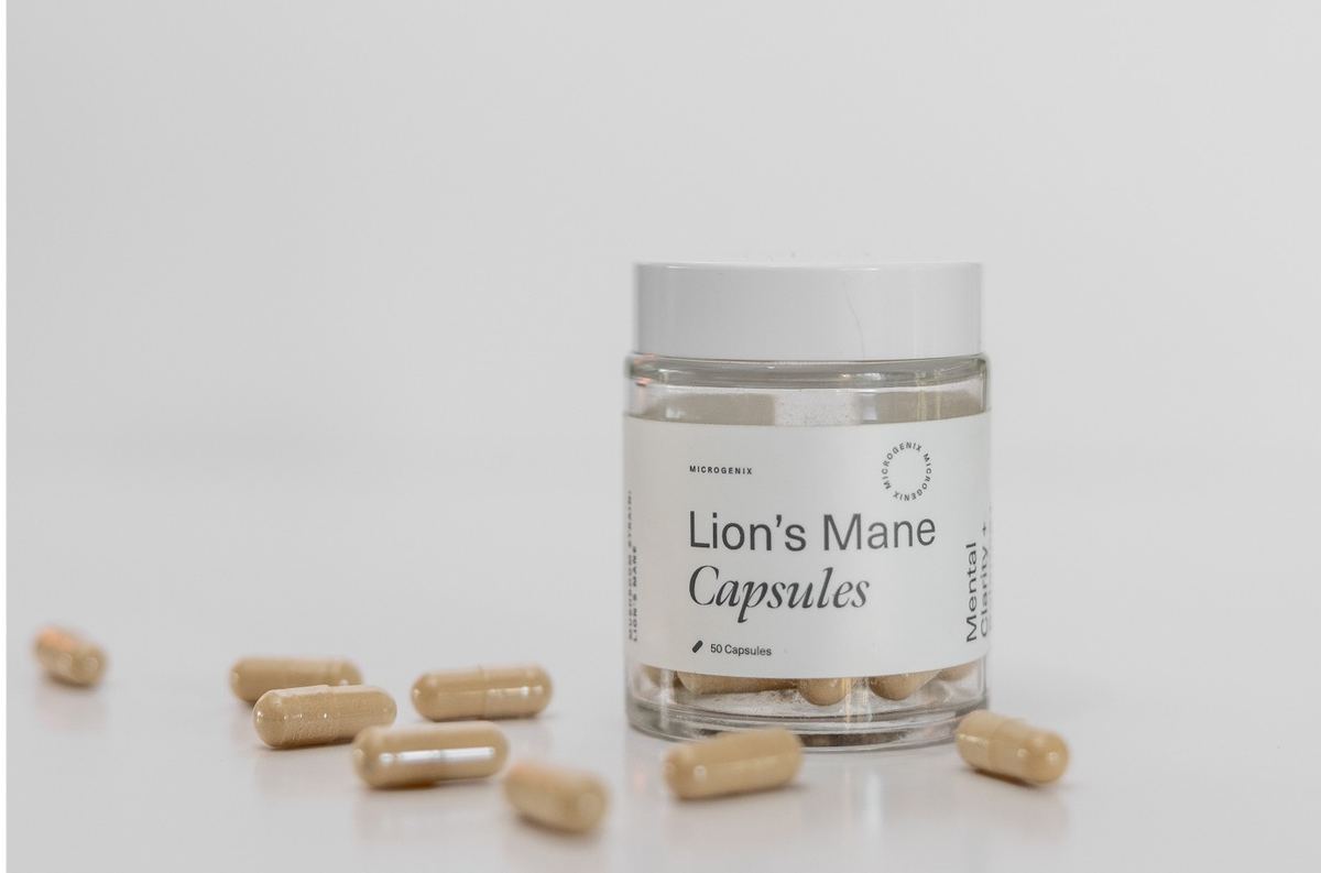 Lion's Mane Capsules jar on white with loose capsules scattered in front
