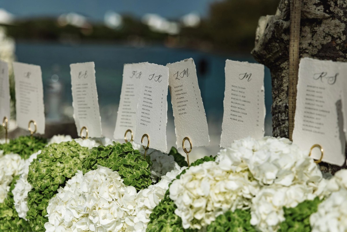 Handwritten escort cards set in white and green hydrangeas on Hawkins Island, Bermuda