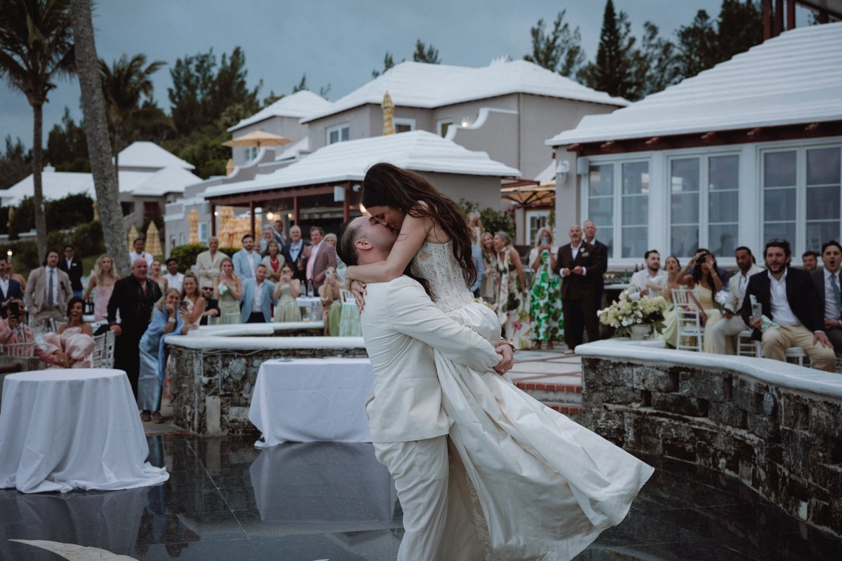Triumphant lift and kiss between bride and groom during first dance
