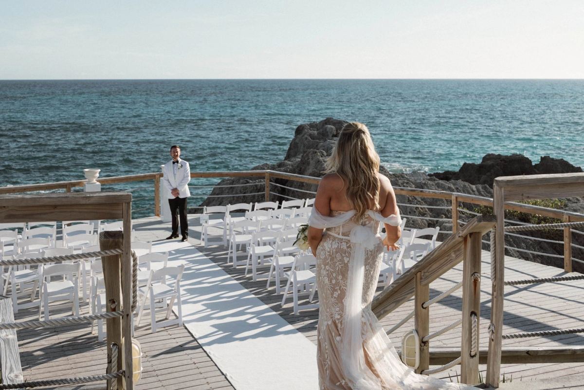 Bride approaching ceremony aisle with ocean view at Bermuda destination wedding