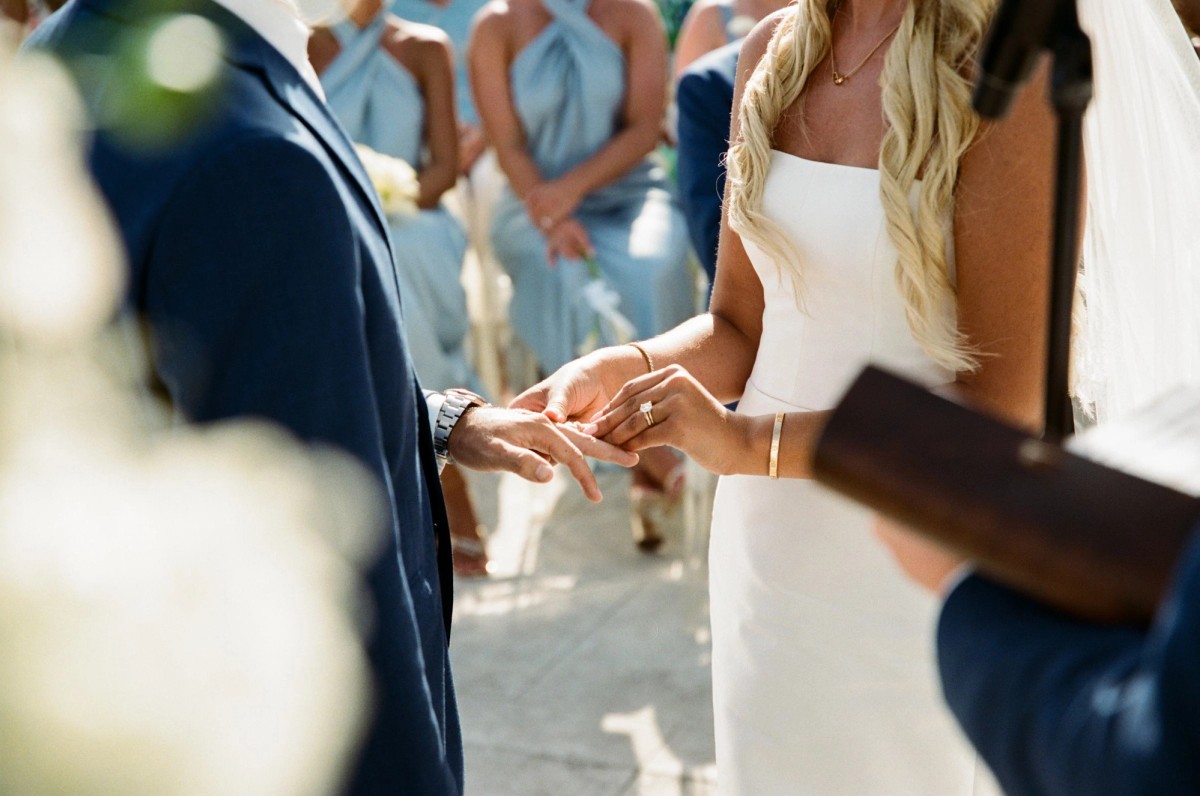 Paige places the ring on Cam's finger as the bridesmaids look on on Hawkins Island, Bermuda, on film