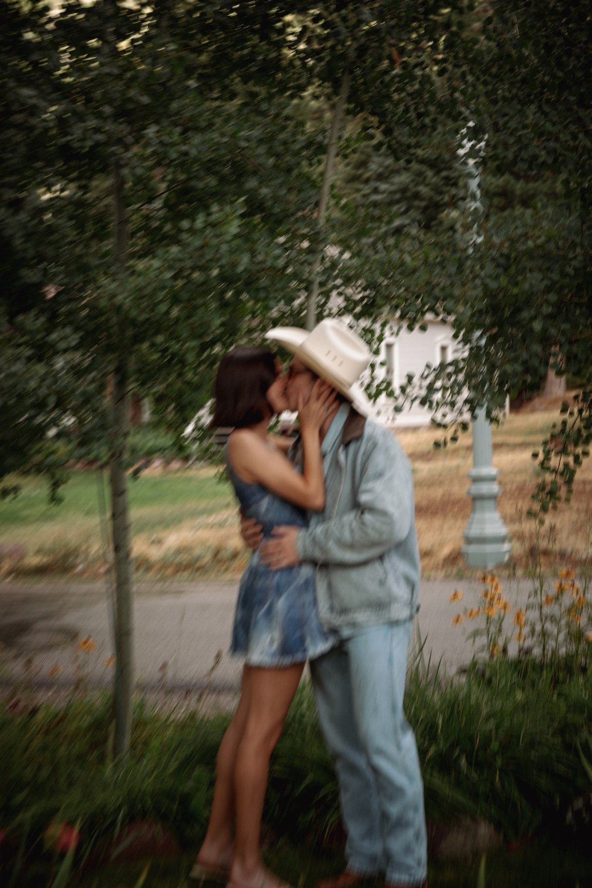 Devin kisses Owen in his cowboy hat under the trees at a mountain ranch among the aspens