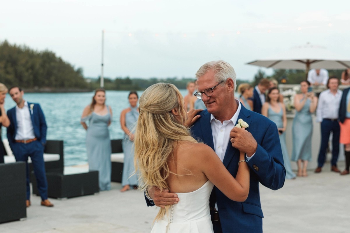 Paige dances with her father as the bridal party watches on Hawkins Island, Bermuda