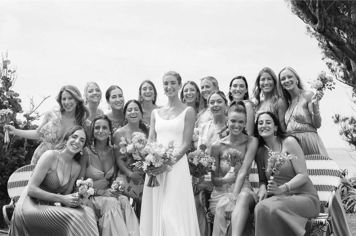 Black and white group portrait of the bride with her bridesmaids and bouquets