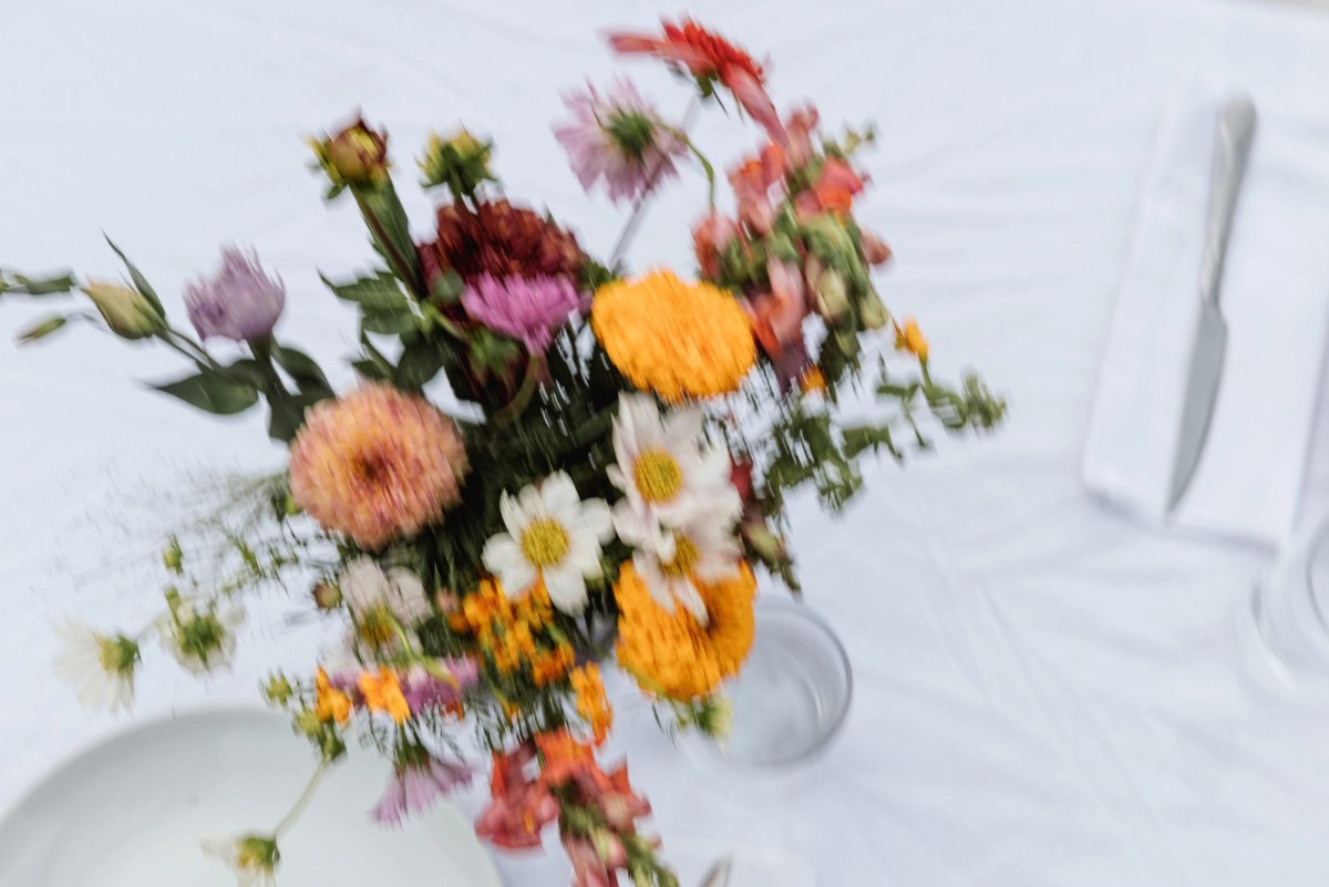 Wildflower bouquet of dahlias and marigolds on a white tablecloth at a mountain ranch among the aspens