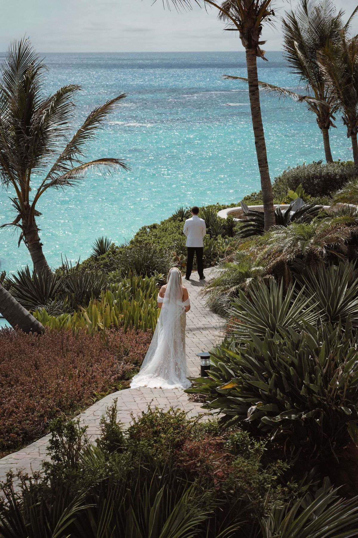 Bride and groom walking through palm trees at Bermuda destination wedding