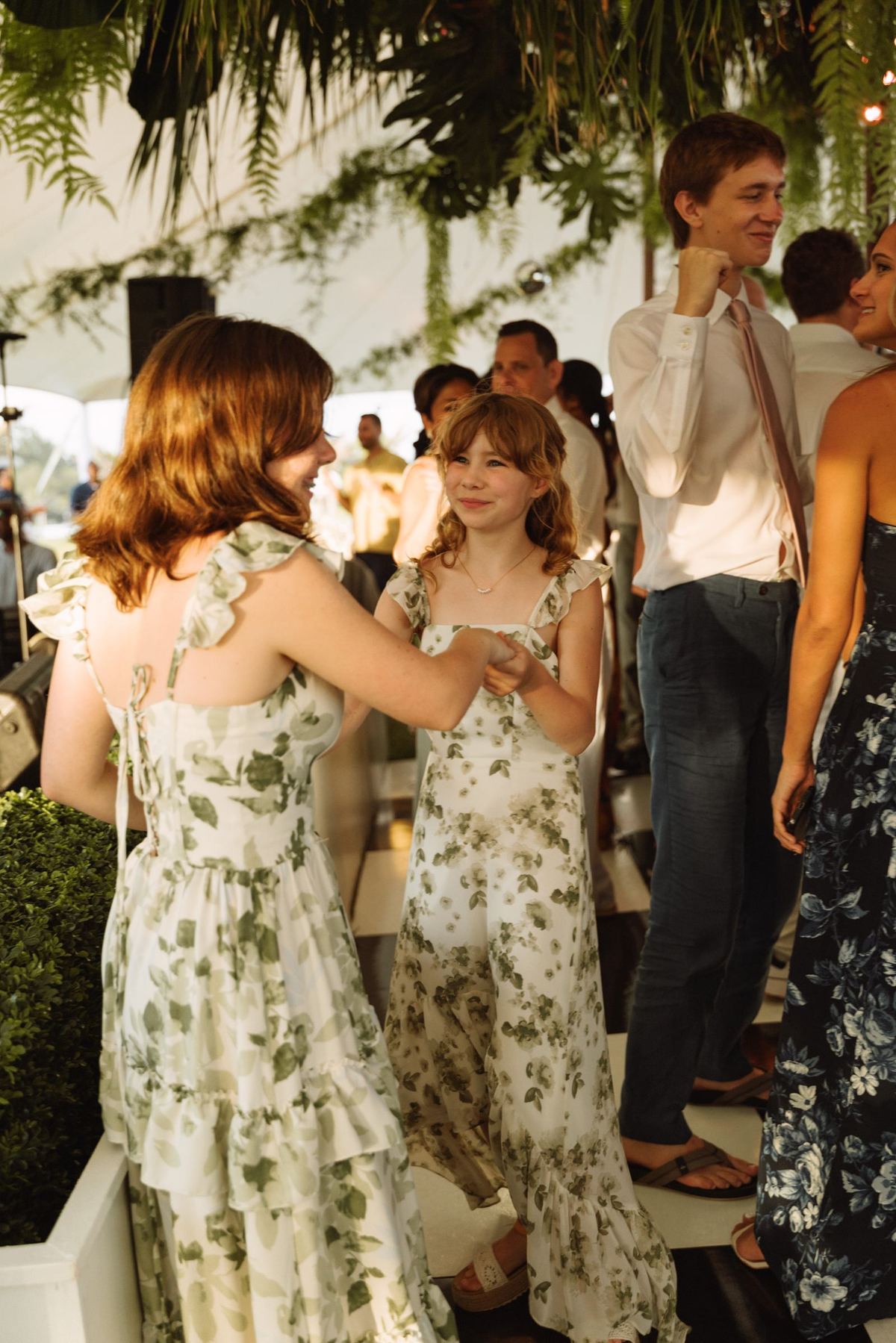Two guests in floral dresses dancing close at a Bermuda wedding reception