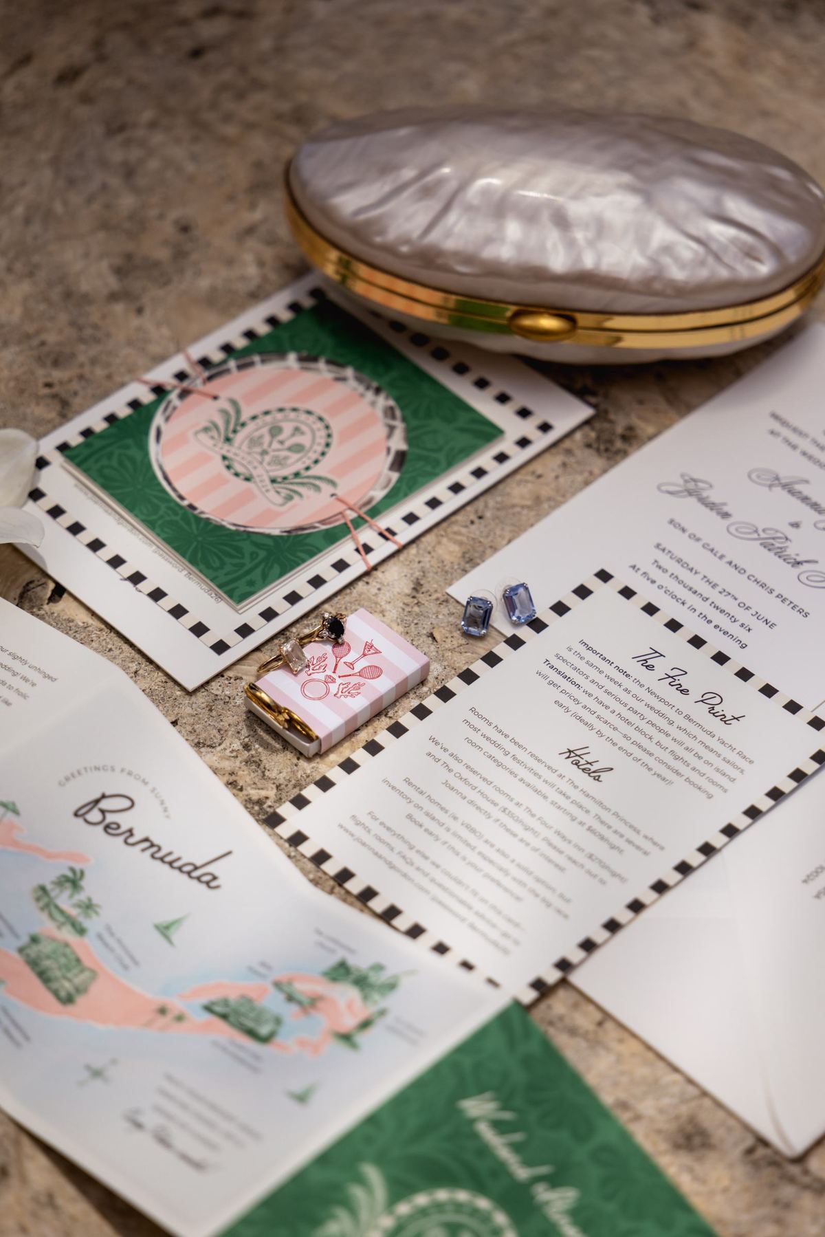 Flat lay of the wedding invitation suite with a Bermuda map and a vintage compact