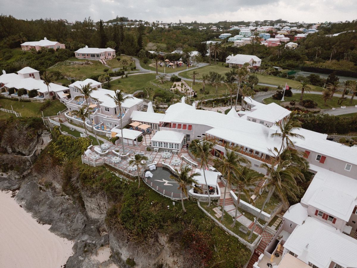 Aerial view of pink Bermuda resort on rocky cliffs at oceanfront wedding venue
