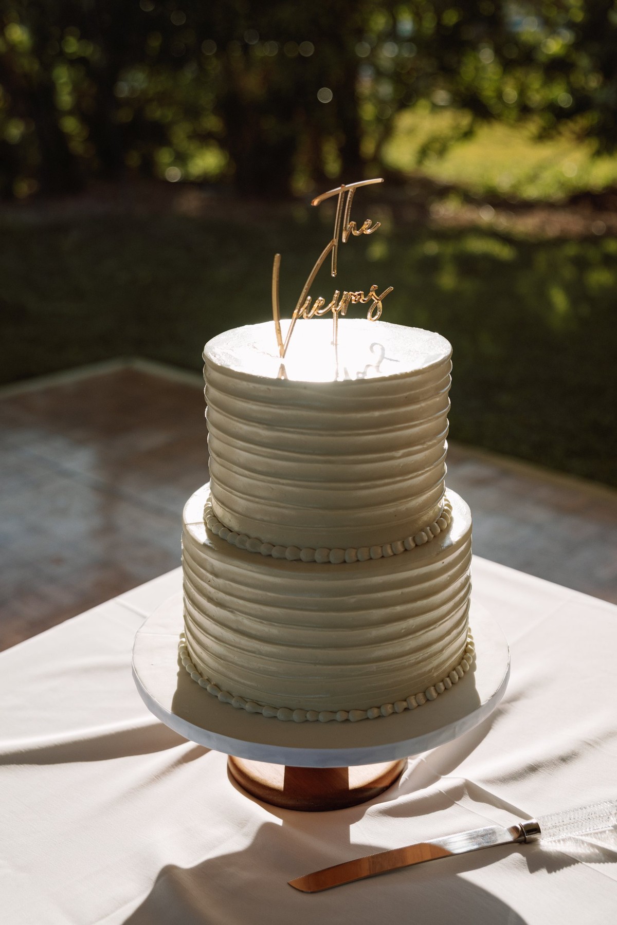 Two tier wedding cake with a gold topper at a Bermuda reception