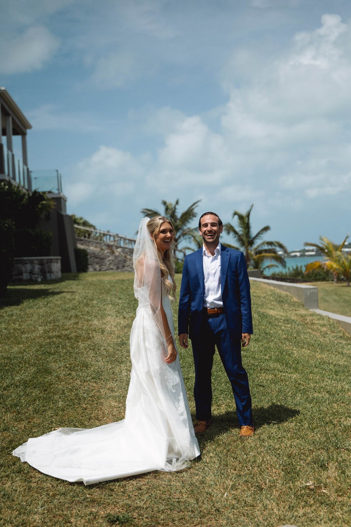 Paige and Cam stand together on the lawn by the water after the first look on Hawkins Island, Bermuda