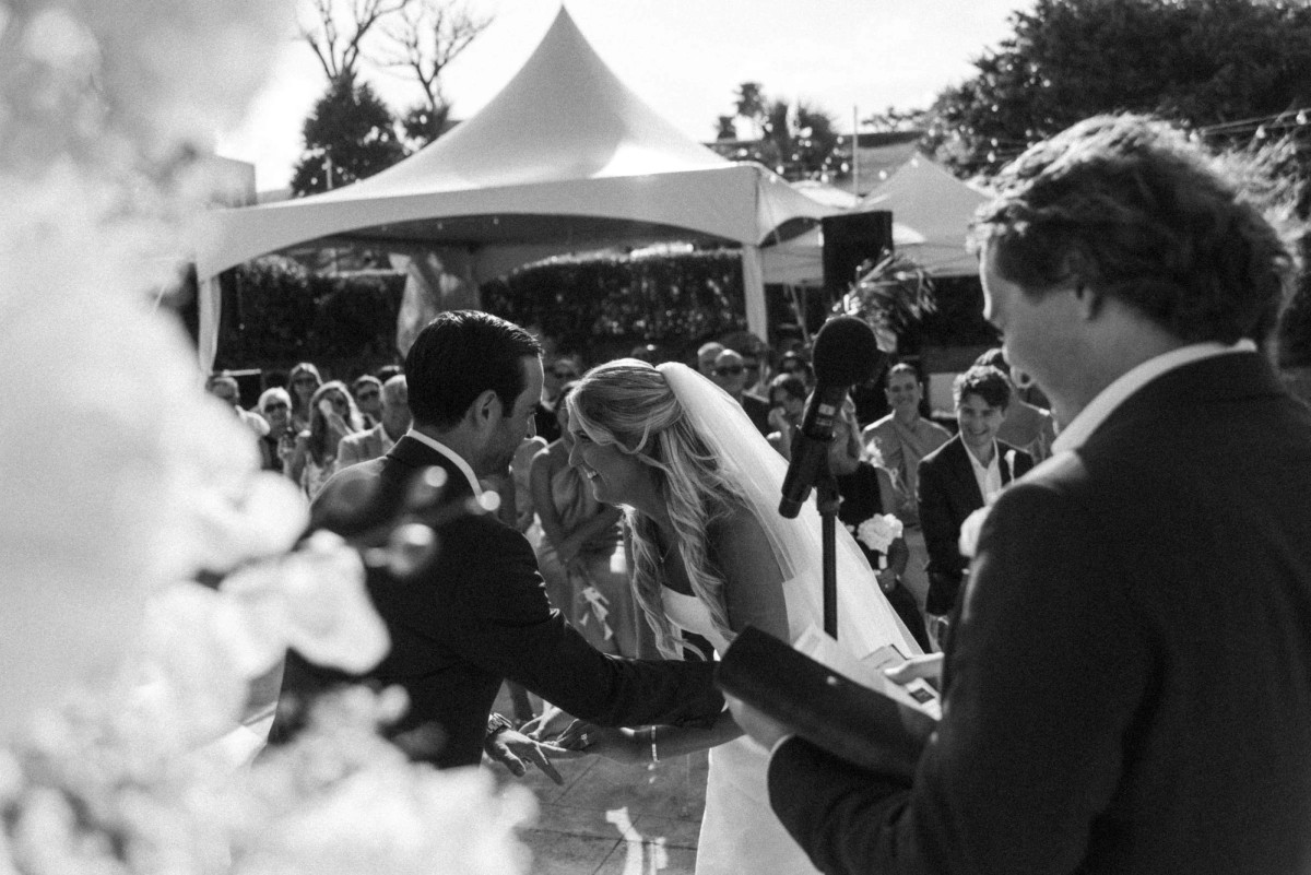 The officiant reads as Paige and Cam stand under the tent on Hawkins Island, Bermuda, black and white