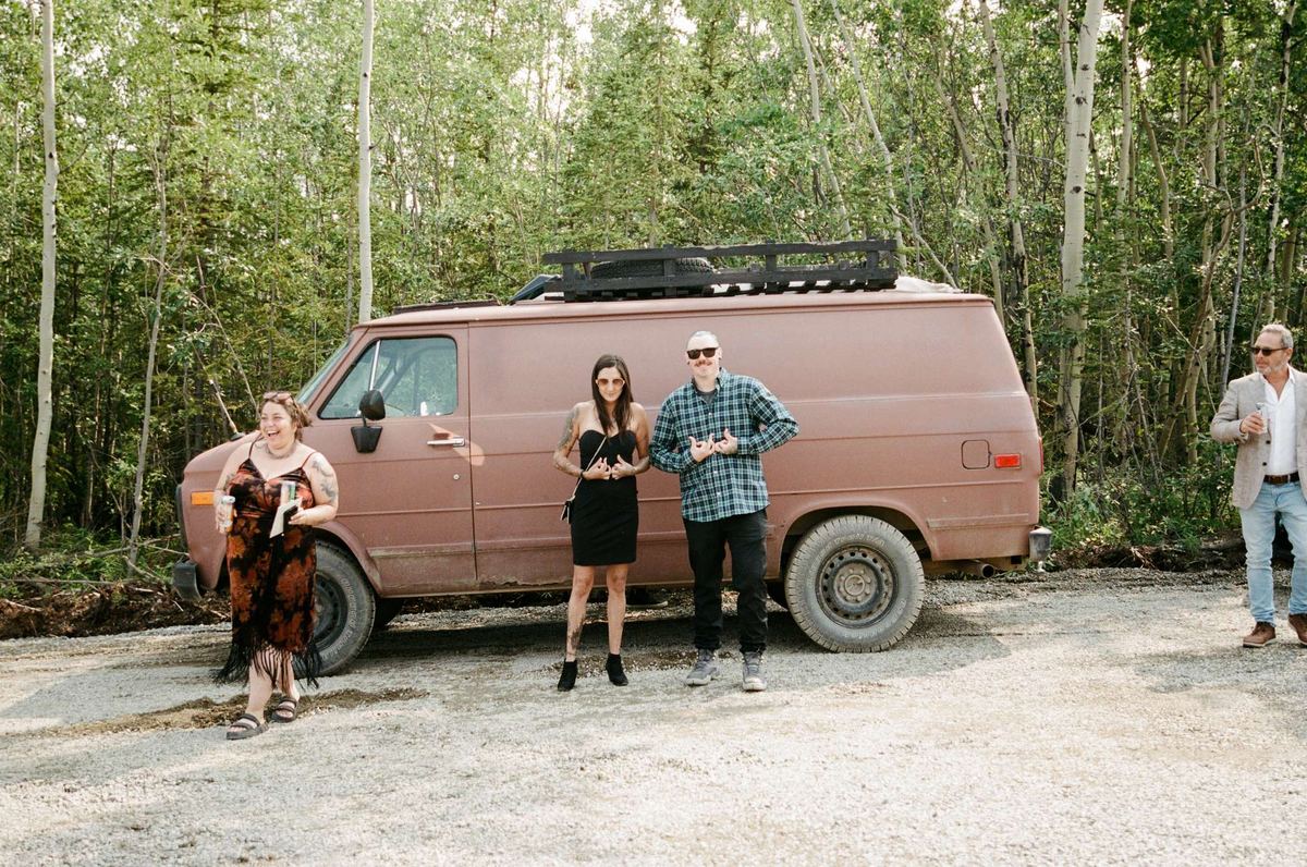 Vintage brown van parked in the boreal forest at a mountaintop wedding